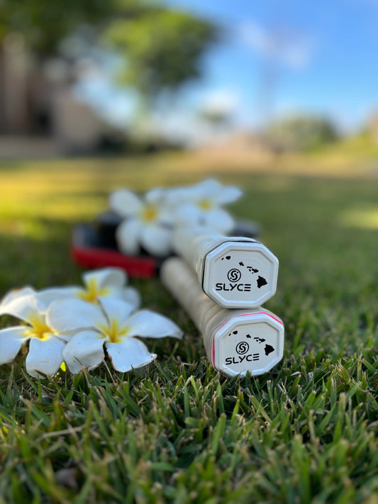 Two SLyce octagonal caps standing on grass, showing SLyce logo on top