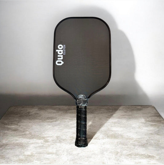 Pickleball paddle with dark graphite face and textured handle grip