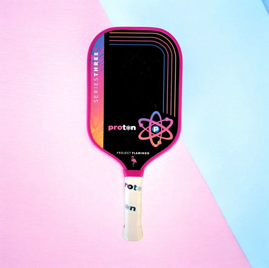 Proton elongated paddle with white handle and pink frame; atom logo on dark face.