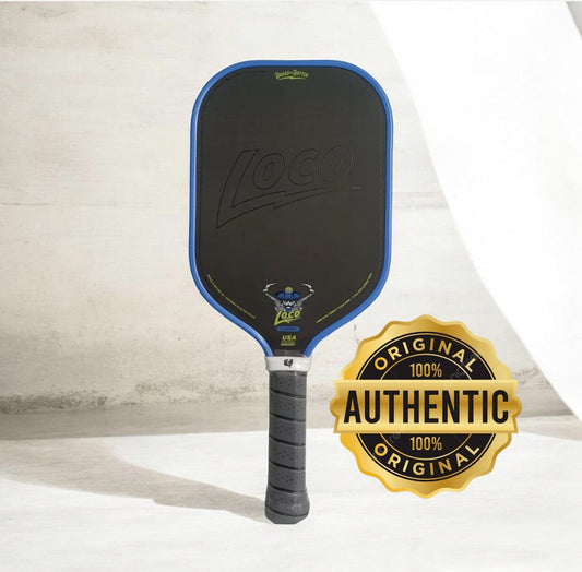 Elongated pickleball paddle with blue border, dark face, and black grip handle; authentic badge