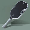 Elongated pickleball paddle with dark face, white outline, and light grip handle