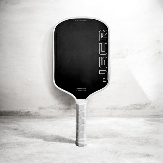 Pickleball paddle with black face, white border, and clear grip handle