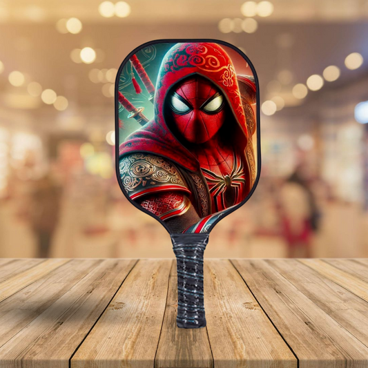 Pickleball paddle with red-and-green hooded character graphic, black handle