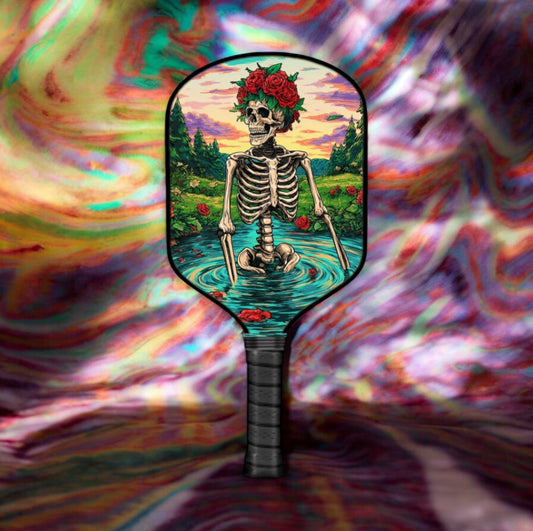 Pickleball paddle with skull-and-rose artwork on a dark face