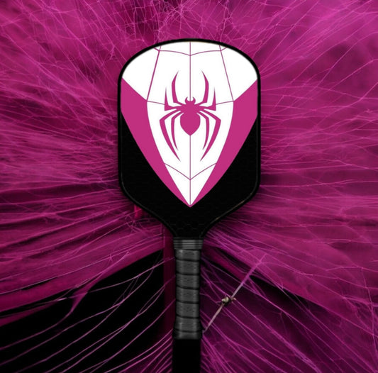 Black pickleball paddle face with white spider logo and purple shield graphic