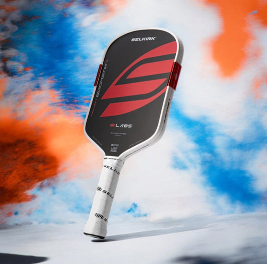 Elongated pickleball paddle standing with black and red face graphics, white grip