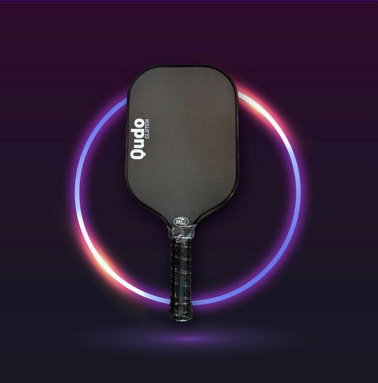 Pickleball paddle with dark face and textured handle grip, Qudo Clutch branding