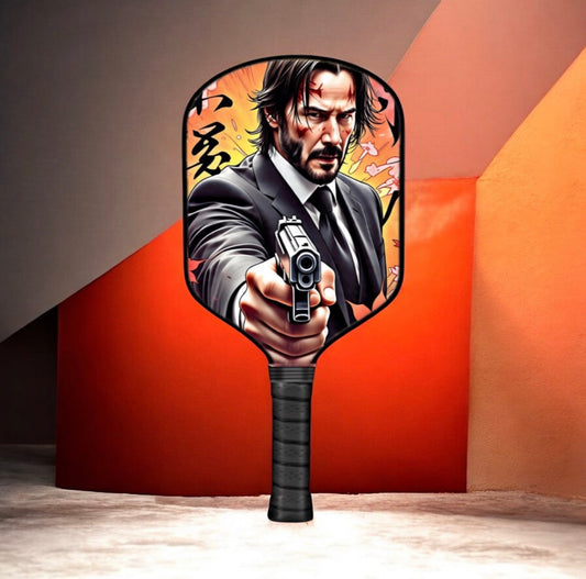Pickleball paddle with black handle and round face featuring character pistol graphic