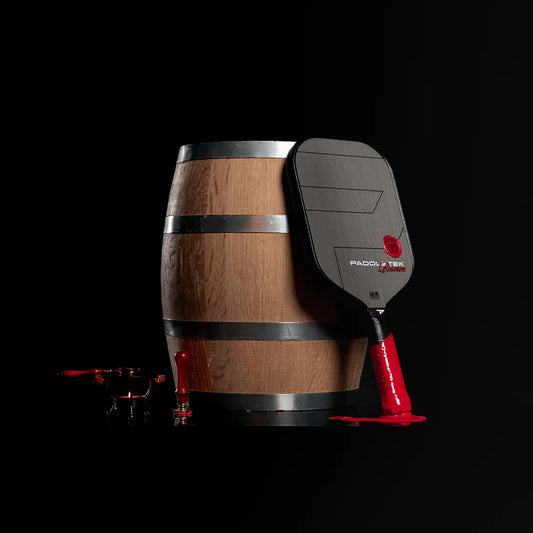 Pickleball paddle with brown wooden-look barrel grip, black handle, and red accents