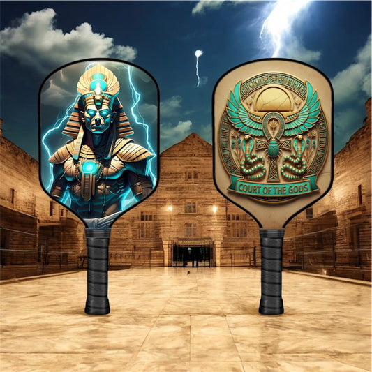 Osiris-themed pickleball paddle, black grip with teal-gold Egyptian face on paddle surface