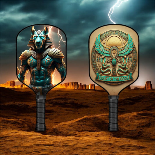 Pickleball paddle with teal-and-gold cat god graphic, dark gray grip