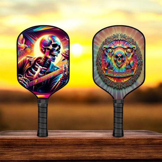 Pickleball paddle with colorful skull and bear graphics, black handle, rounded face.