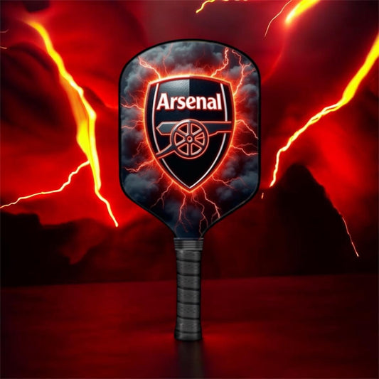 Black pickleball paddle with Arsenal shield graphic on a dark face, textured handle