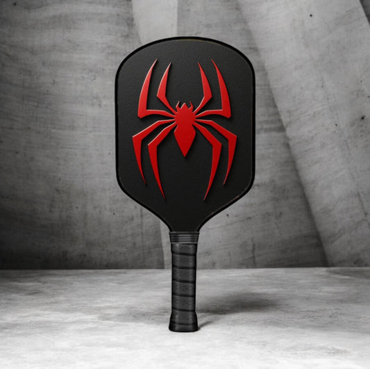 Black pickleball paddle with red spider logo graphic on face