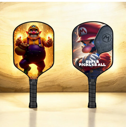 Wario-themed pickleball paddle with black grip and oval face art, full paddle view